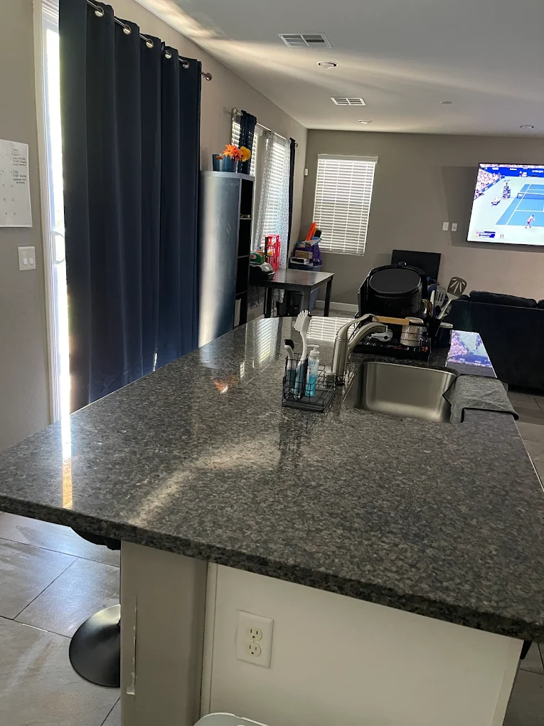 After cleaning: spotless kitchen counters and sink area with polished surfaces
